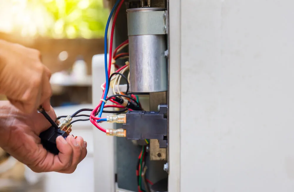 Close up of a repairman fixing air conditioning system, changing magnetic contactor