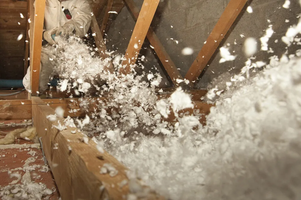 Blown insulation being installed in an attic