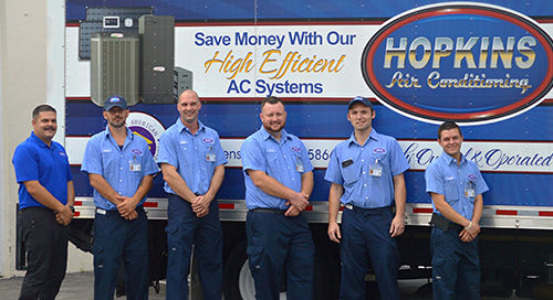 Hopkins Air technicians standing in front of a Hopkins Air service truck