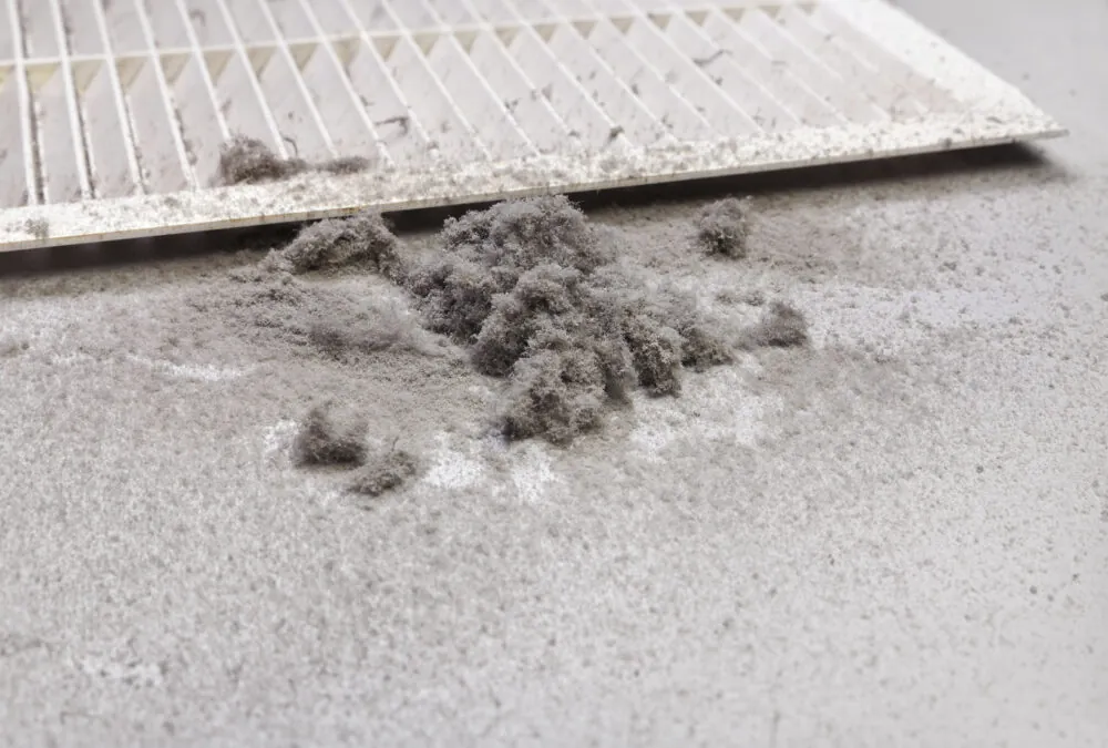Vent cover removed with clumps of dust from the air ducts